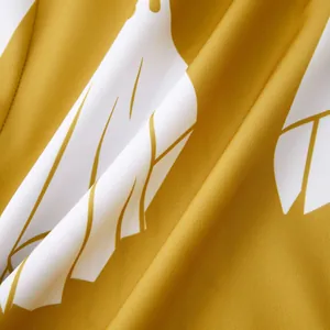 Vista ravvicinata della trama del tessuto floreale giallo senape per camicia da uomo.