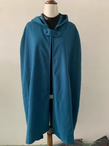 Lange damesmantel met capuchon in pauwblauw op een etalagepop gepresenteerd.