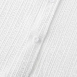 Primer plano detallado de la textura de tela blanca arrugada y botones de la camisa