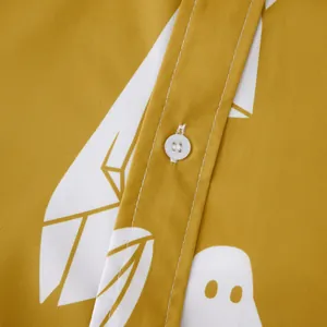 Dettaglio di bottone bianco e cuciture su camicia gialla da uomo con stampa fantasma