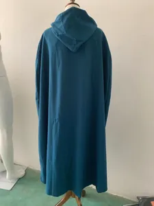 Gedetailleerd achteraanzicht van een lange groenblauwe mantel met capuchon op een paspop