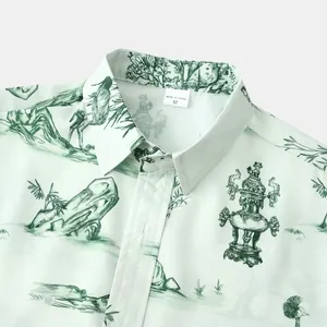 Détail d'une chemise hawaïenne à manches courtes avec imprimé paysage vert clair.
