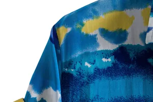 Close-up detail of abstract blue and yellow watercolor print on men's casual shirt