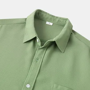 Close-up detail of sage green textured fabric on a men's casual short-sleeved shirt
