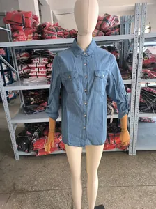 Classic blue denim shirt with long sleeves and front pockets shown on a professional mannequin.