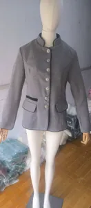 Detail of women's grey wool jacket featuring ornate silver buttons and black piping