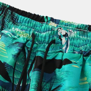 Close-up detail of tropical palm print beach shorts featuring elastic drawstring waistband