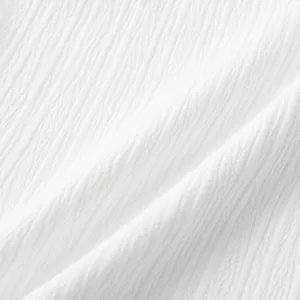 Primer plano detallado de tela de algodón texturizada blanca para camisa de verano de hombre