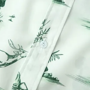 Gros plan sur le bouton et l'imprimé nature vert d'une chemise hawaïenne blanche