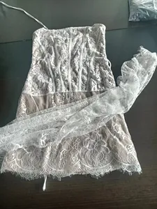 Detailed view of white floral lace corset dress with sheer mesh and delicate piping