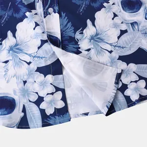 Close-up detail of the hem and white buttons on a navy blue skull floral print shirt.