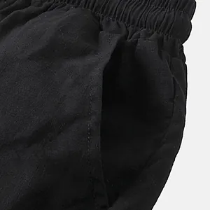 Close-up detail of side pocket and elastic waistband on men's black cotton linen shorts