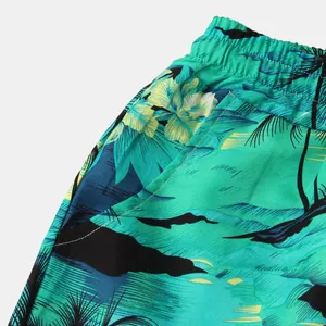 Close-up of elastic waistband and pocket on men's tropical print beach shorts.