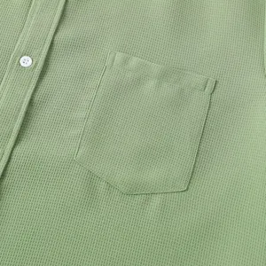 Close-up of waffle texture and chest pocket on men's light green casual shirt.