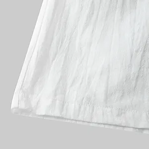 Close-up view of white cotton linen fabric texture and hem of men's beach shorts