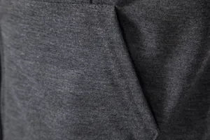 Gros plan sur la texture du tissu gris foncé et les coutures d'une poche de gilet