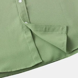 Close-up of green waffle texture fabric on men's casual shirt with white buttons
