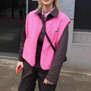 Detail view of a vibrant pink sleeveless fleece vest featuring a single-breasted button closure