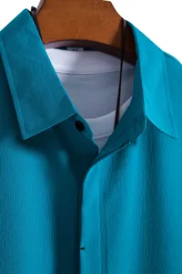 Close-up of teal men's short sleeve shirt showing fabric texture and collar detail