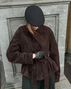 Vintage braune Wildlederjacke mit Gürtel an einem Model in einer stilvollen Umgebung.