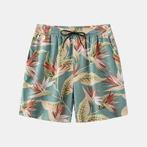 Macro view of tropical bird of paradise floral print on men's beach shorts.