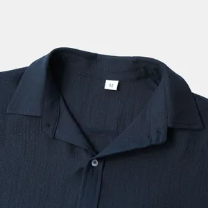 Detail shot of navy blue men's short sleeve shirt showing collar and crepe texture