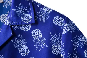 Close-up detail of men's Hawaiian shirt with white pineapple print on blue fabric