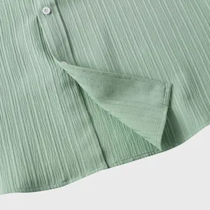 Primer plano de la tela texturizada transpirable verde claro de camisa para hombre