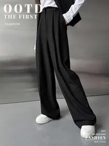 Détail d'un pantalon noir large pour femme avec drapé élégant et taille haute plissée