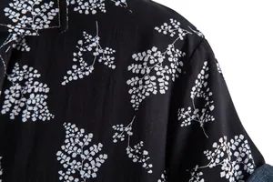 Close-up detail of the intricate white leaf pattern on a black casual short sleeve shirt.