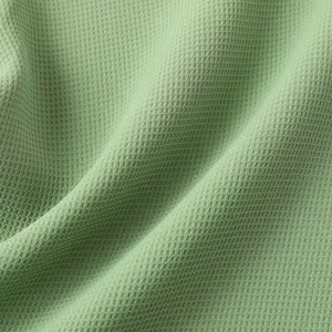 Close-up of sage green waffle weave fabric for a breathable and casual men's summer shirt