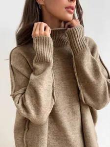 Detail view of a cozy thick turtleneck knit sweater in brown with ribbed texture.