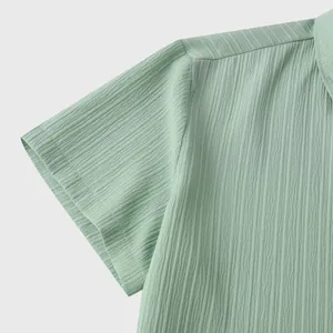 Detalle de la manga de una camisa de verano para hombre en verde con textura rugosa