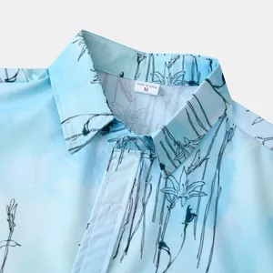 Gros plan du col d'une chemise hawaïenne à manches courtes à fleurs bleu clair.