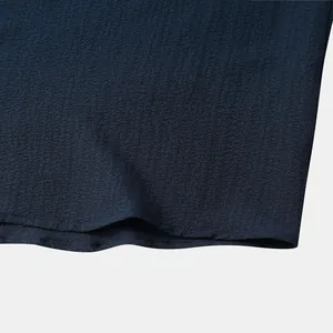 Macro detail of the navy blue seersucker textured fabric of a men's summer shirt