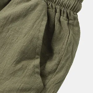 Close-up detail of olive green men's cotton linen shorts with elastic waist and pocket.