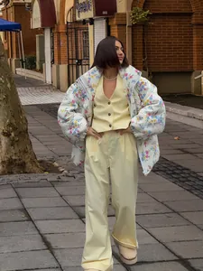 Model wearing floral quilted puffer jacket with yellow vest and wide-leg trousers