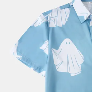 Primo piano di una camicia a maniche corte da uomo azzurra con motivo a fantasmi bianchi.