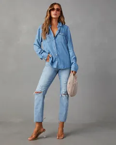 Full view of a casual light blue denim shirt with distressed jeans and accessories.