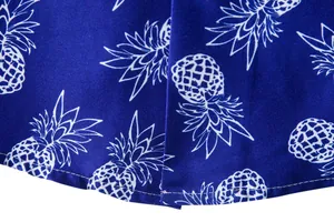 Detailed macro view of white pineapple print pattern and stitching on blue Hawaiian shirt fabric