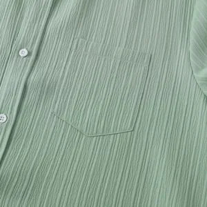 Primer plano de la tela verde salvia y bolsillo de una camisa de verano para hombre