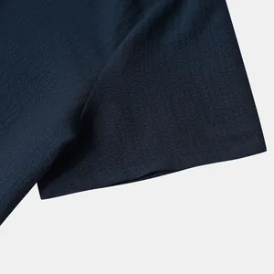 Macro view showing the fine textured navy blue fabric of a men's short sleeve shirt