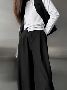 Gros plan détaillé sur un pantalon de costume noir fluide et large à la coupe ample moderne