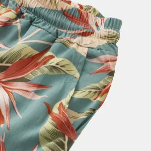 Close-up of tropical floral print shorts featuring elastic waistband and side pocket detail