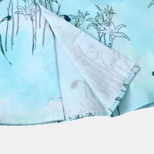 Détail de la fente latérale d'une chemise hawaïenne pour homme bleu clair à fleurs.