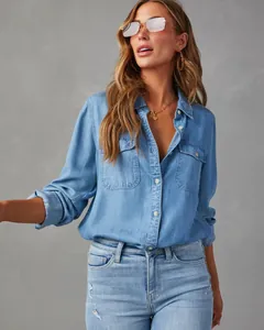 Detailed view of women's light blue long sleeve denim shirt with front pockets