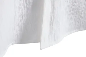 Macro view of white textured fabric and hem stitching on men's summer shirt.