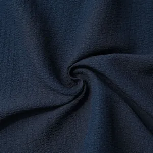 Close-up macro detail of dark navy blue men's shirt fabric showing woven texture