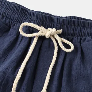 Close-up view of the elastic waistband and braided drawstring on navy cotton linen shorts