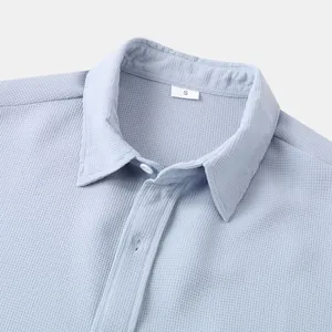 Detailed close-up showing light blue men's waffle textured shirt collar and top buttons